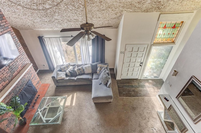 living room with ceiling fan, brick ceiling, a fireplace, and carpet