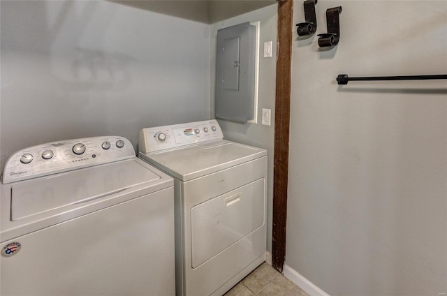 clothes washing area with electric panel, washing machine and dryer, and light tile patterned floors