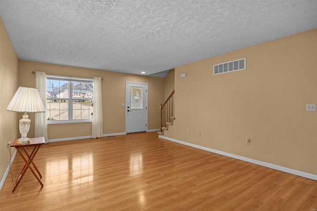 interior space with a textured ceiling and light wood-type flooring