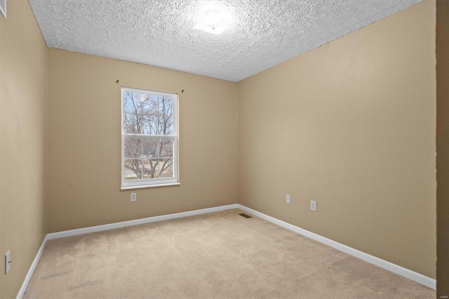 carpeted spare room with a textured ceiling