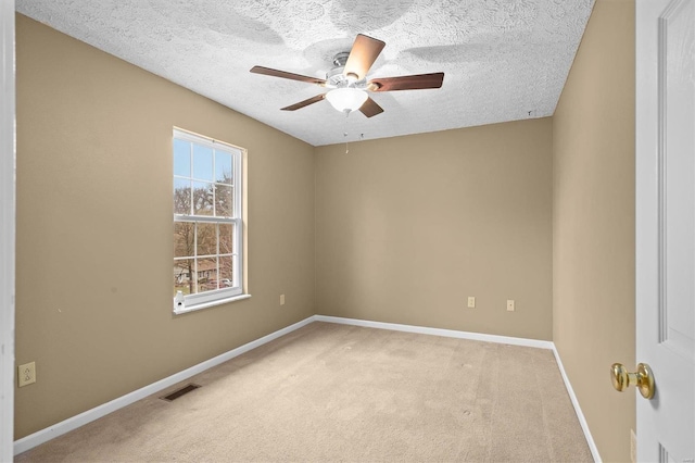 carpeted empty room with ceiling fan and a textured ceiling