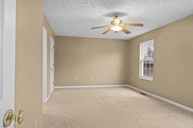 carpeted spare room with ceiling fan and a textured ceiling