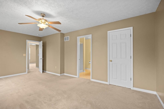 unfurnished bedroom featuring light carpet, ceiling fan, and a textured ceiling