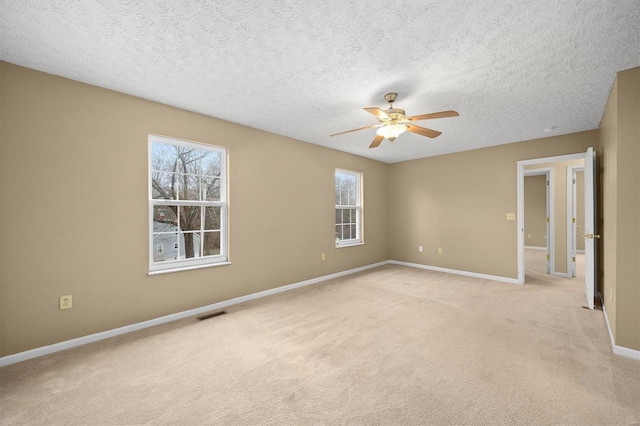 carpeted empty room with a textured ceiling and ceiling fan