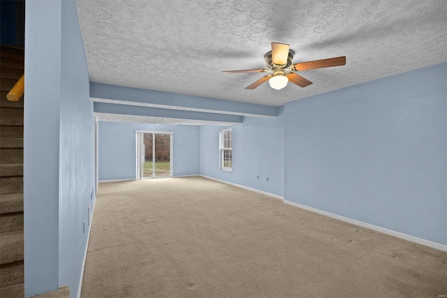 carpeted empty room with ceiling fan and a textured ceiling