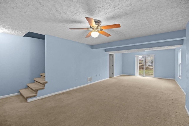 unfurnished living room with light carpet, ceiling fan, and a textured ceiling