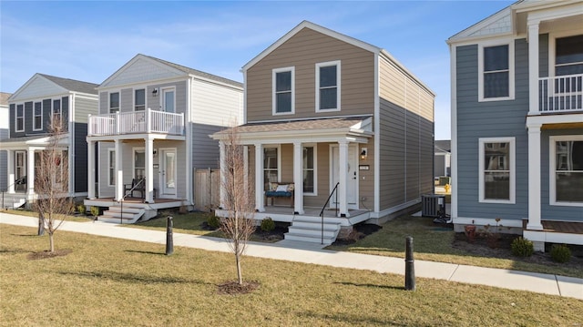 view of front facade with covered porch, central AC unit, and a front lawn