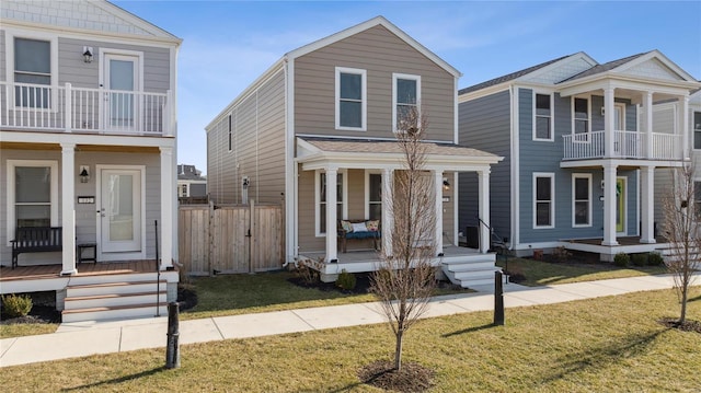 view of front of home with a porch, a front lawn, and a balcony