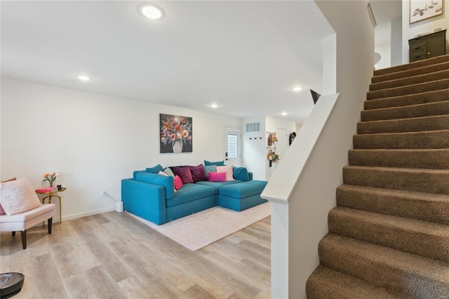 living room featuring recessed lighting, visible vents, light wood-style flooring, baseboards, and stairs