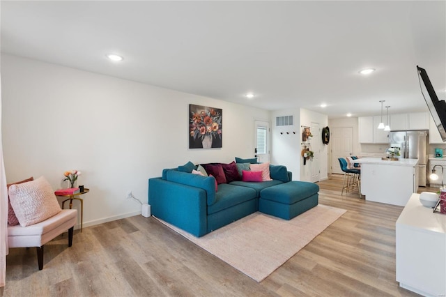 living area featuring light wood-type flooring, visible vents, baseboards, and recessed lighting