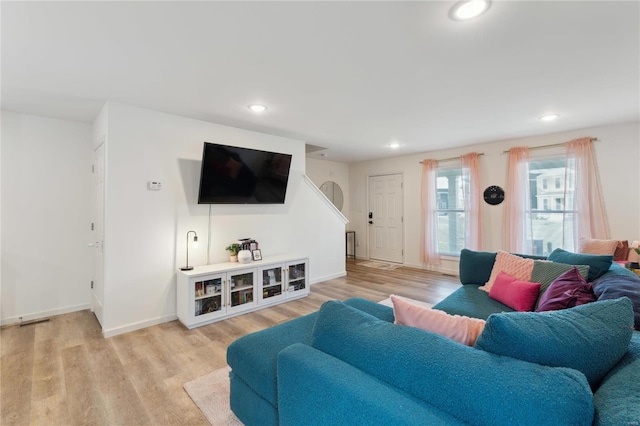 living area with baseboards, light wood-style flooring, and recessed lighting