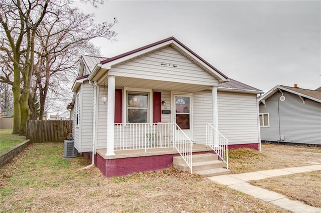 bungalow-style house featuring central AC, a porch, and a front yard