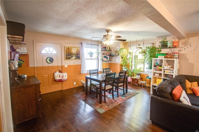 dining space featuring ceiling fan, dark wood-type flooring, and a textured ceiling