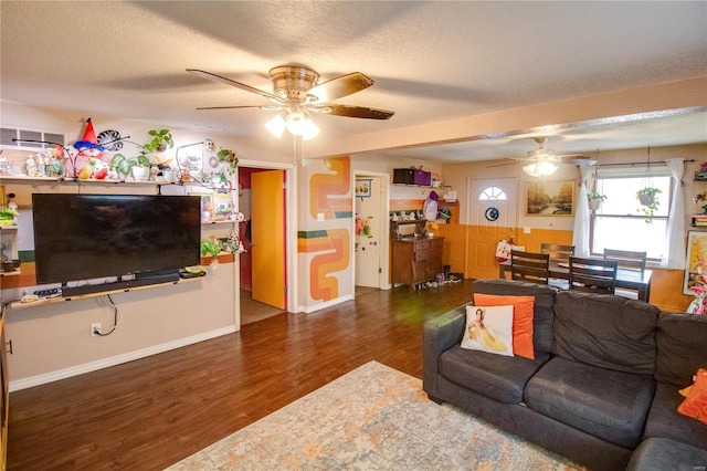 living room with ceiling fan, dark hardwood / wood-style floors, and a textured ceiling