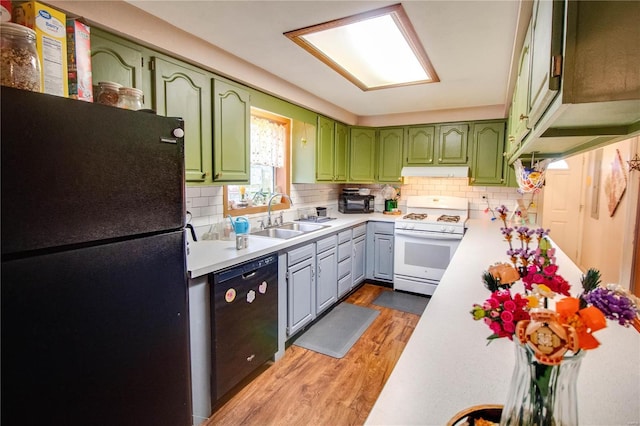 kitchen featuring green cabinetry, tasteful backsplash, sink, and black appliances