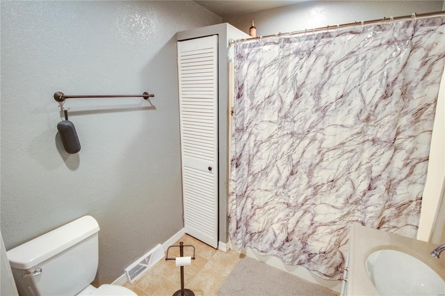 bathroom featuring vanity, toilet, curtained shower, and tile patterned flooring