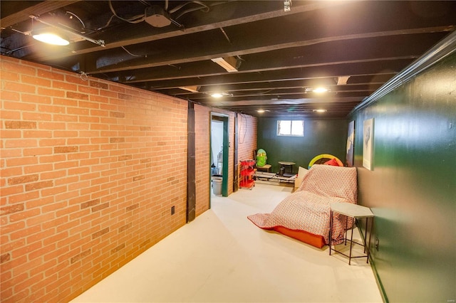 living area featuring concrete flooring and brick wall