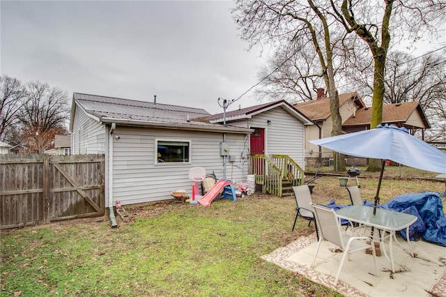 back of house featuring a patio area and a lawn