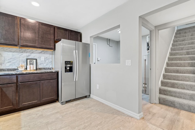 kitchen with dark brown cabinetry, stainless steel fridge, baseboards, and decorative backsplash