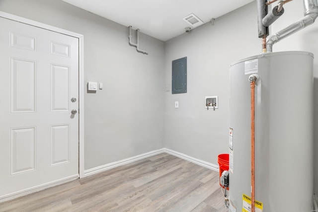 washroom with gas water heater, laundry area, baseboards, light wood-type flooring, and electric panel