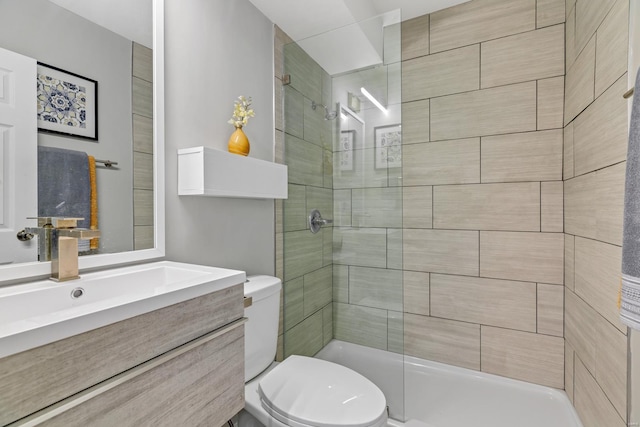 bathroom with a stall shower, vanity, and toilet