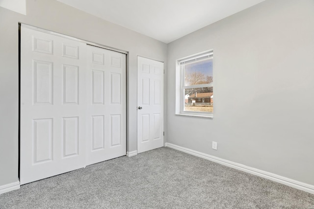 unfurnished bedroom featuring carpet, baseboards, and a closet