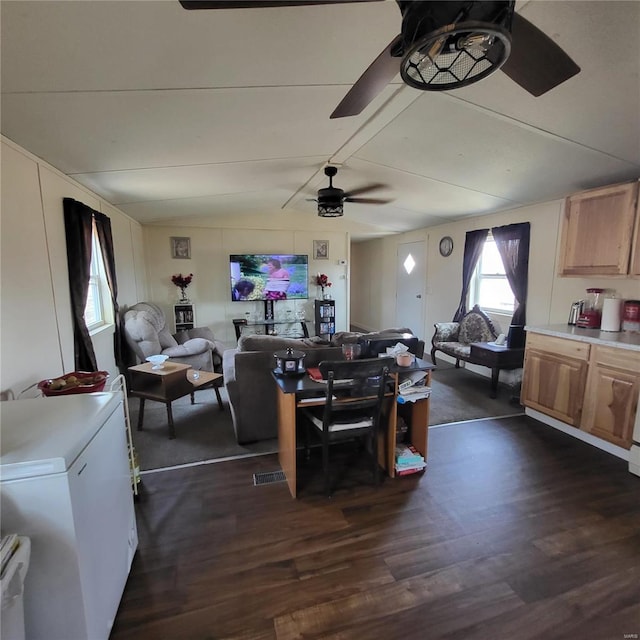 living room with ceiling fan, dark hardwood / wood-style floors, and vaulted ceiling with beams