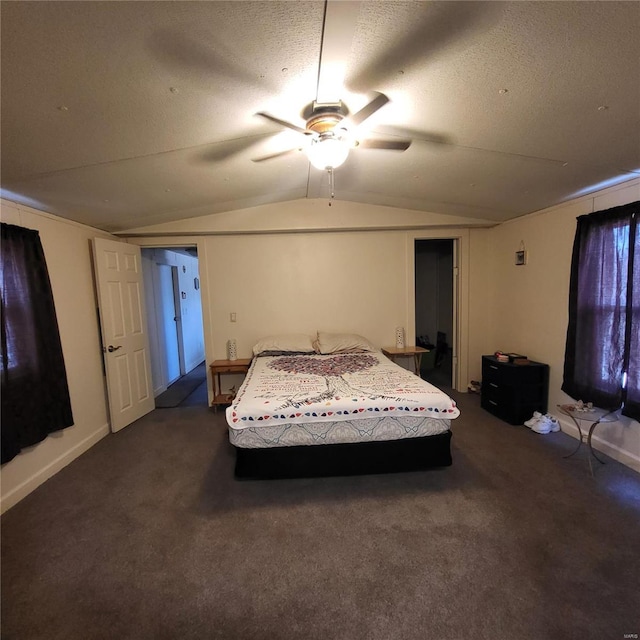 bedroom featuring ceiling fan, vaulted ceiling, a textured ceiling, and dark colored carpet