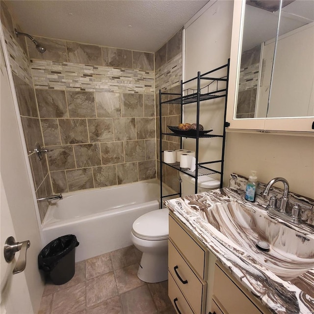 full bathroom featuring tiled shower / bath combo, vanity, a textured ceiling, and toilet