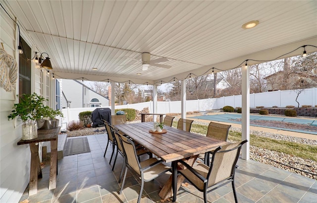 view of patio / terrace with grilling area, a covered pool, and ceiling fan