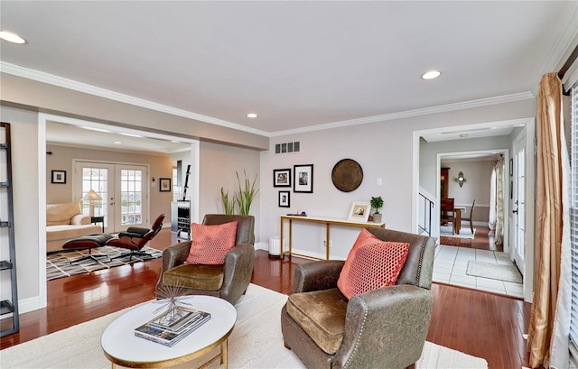 living room featuring hardwood / wood-style floors, ornamental molding, and french doors