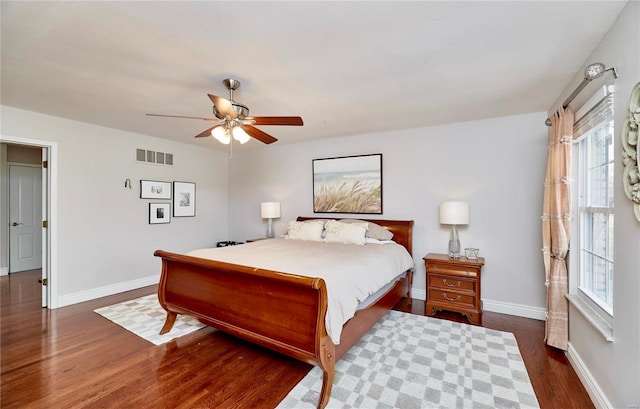 bedroom with multiple windows, dark hardwood / wood-style floors, and ceiling fan