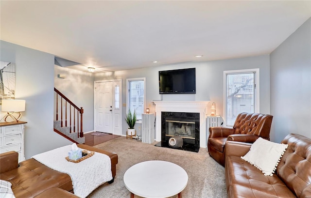 living room with a premium fireplace and carpet flooring