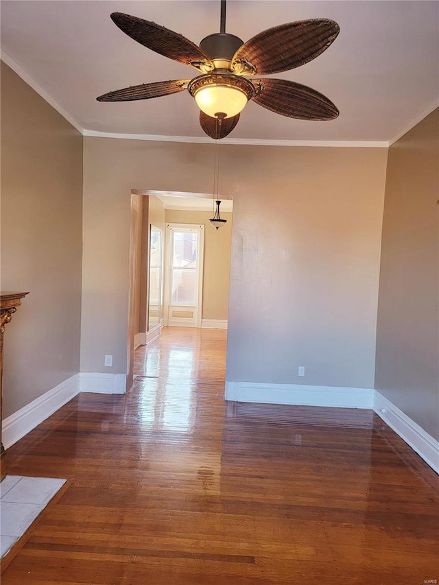 spare room featuring ornamental molding, dark wood finished floors, and baseboards