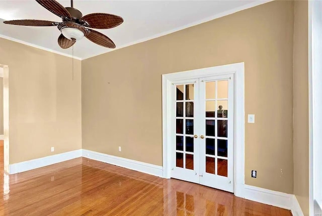 spare room featuring baseboards, wood finished floors, and french doors