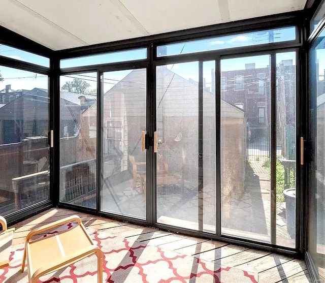 doorway to outside featuring a wall of windows and wood finished floors