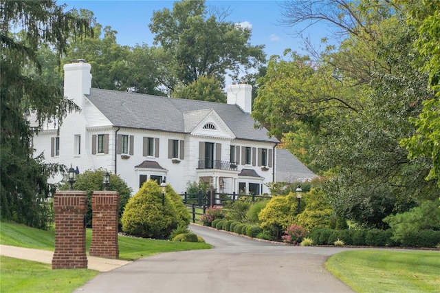 view of front of property with a balcony and a front lawn