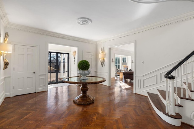 foyer with crown molding and dark parquet flooring