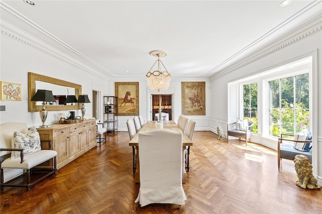 dining room with an inviting chandelier, ornamental molding, and dark parquet flooring