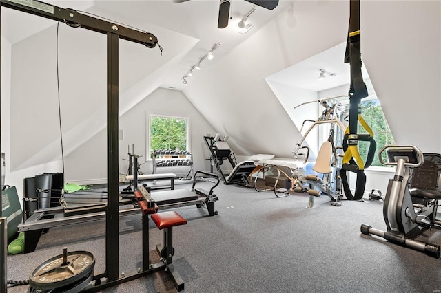 workout room featuring vaulted ceiling, track lighting, and ceiling fan