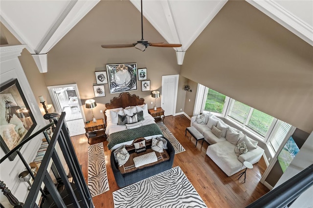 bedroom with hardwood / wood-style floors, high vaulted ceiling, and ceiling fan