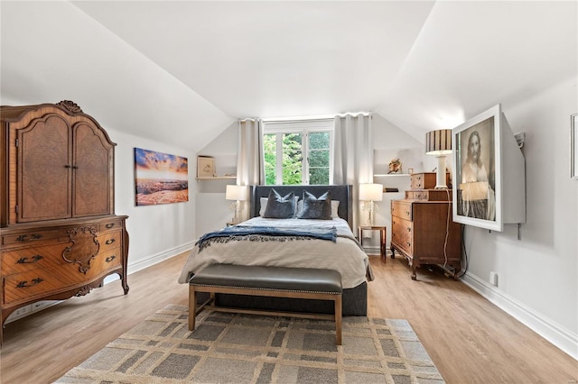 bedroom featuring lofted ceiling and light hardwood / wood-style flooring