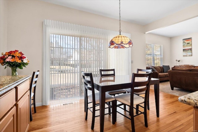 dining room with light wood-type flooring and visible vents