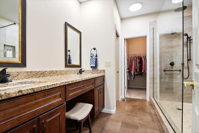 full bathroom with a stall shower, a sink, a spacious closet, and double vanity