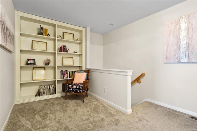 sitting room with carpet, an upstairs landing, and baseboards