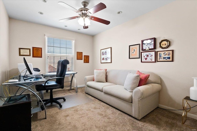 carpeted office with a ceiling fan and baseboards