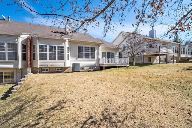 rear view of house featuring a chimney, a deck, central AC, and a yard