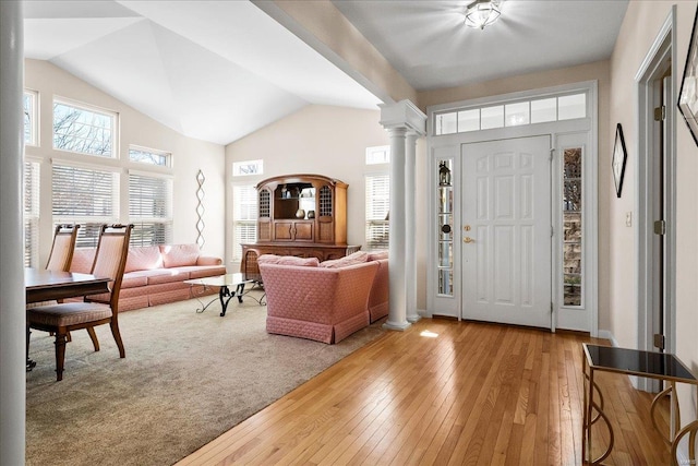 entrance foyer with lofted ceiling, decorative columns, baseboards, and wood-type flooring