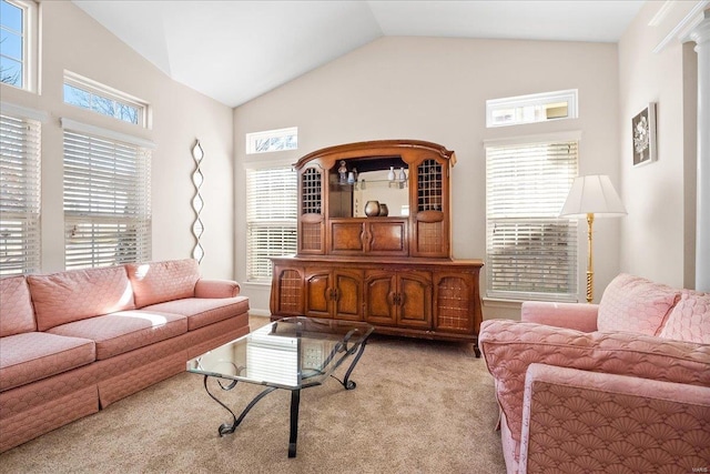 living room with light carpet, a healthy amount of sunlight, and lofted ceiling