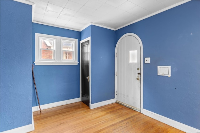 entryway featuring hardwood / wood-style flooring and crown molding